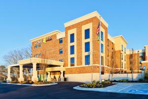 a large brick building with an american flag in front at Home2 Suites By Hilton Alpharetta, Ga in Alpharetta
