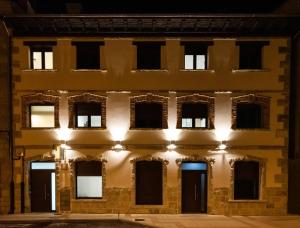 un viejo edificio de noche con luces encendidas en alojamiento cuatro estaciones, en La Pola de Gordón