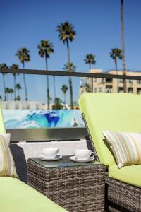un patio con una mesa con dos tazas. en The Fin Hotel, Tapestry Collection by Hilton, en Oceanside