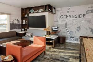 a living room with a couch and a tv at The Fin Hotel, Tapestry Collection by Hilton in Oceanside