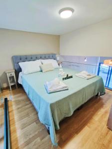 Schlafzimmer mit einem großen Bett mit blauer Tagesdecke in der Unterkunft Avramiou Loft Studio in Ágios Rókkos