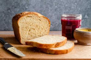 a loaf of bread and a jar of jam on a cutting board at Catba Papillon Garden Bungalows & Resort in Cat Ba