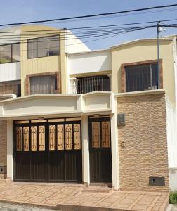 Casa Grande con parqueadero في إبياليز: منزل بأبواب سوداء و طوب