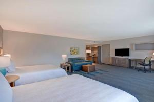 WillistonにあるHome2 Suites Williston Burlington, Vtのベッド2台とテレビが備わるホテルルームです。