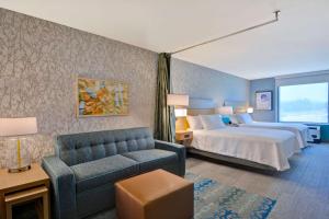 une chambre d'hôtel avec un lit et un canapé dans l'établissement Home2 Suites Williston Burlington, Vt, à Williston