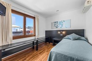 a bedroom with a bed and a desk and a window at Siesta Suites Lanzarote in Yaiza +19 photos