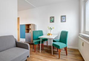 uma sala de estar com uma mesa e cadeiras e um sofá em Ferienhaus Renate FeWo 3 em Bansin
