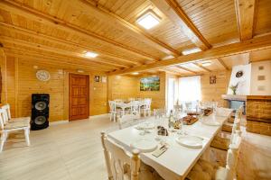 una sala da pranzo con tavoli bianchi e sedie bianche di ViiLa Munte Călimani a Topliţa