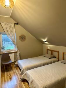 - une chambre avec 2 lits et une fenêtre dans l'établissement Semo guest house with amazing sauna and pool, à Vecumnieki