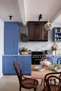 雷島林灘的住宿－Maisons 322 - La Secrète，厨房配有蓝色橱柜和桌椅