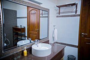 a bathroom with a sink and a large mirror at Cornerstone Villas in Arusha +32 photos