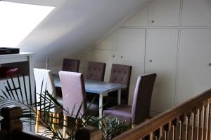 une salle à manger avec des chaises violettes et une table dans l'établissement Le Cèdre, 