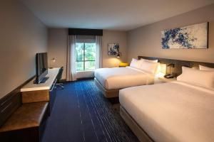 a hotel room with two beds and a flat screen tv at Hilton Garden Inn Redmond Town Center, Wa in Redmond