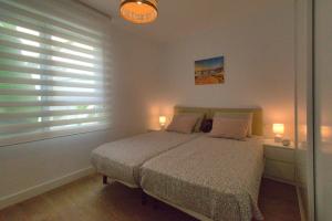 a bedroom with a bed and a window with blinds at THE SEA VIEW CALACEITE in Torrox Costa