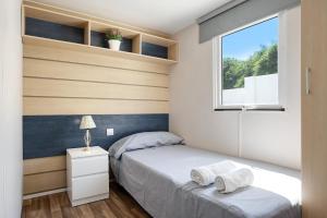 een kleine slaapkamer met een bed en een raam bij Mobile Home Maria Marta in Barbate
