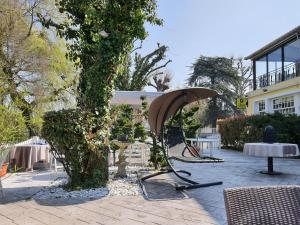 a table and a chair next to a tree at LOGIS - Hôtel & Restaurant Le Gonfalon in Germigny-lʼEvêque
