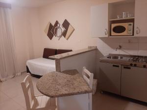 a small kitchen with a sink and a bed at Atlantico Flat Gonzaga in Santos