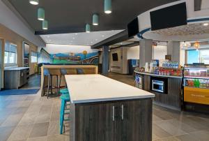 a restaurant with a bar with stools and a kitchen at Tru By Hilton Knoxville West Turkey Creek in Knoxville