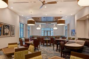 a dining room with tables and chairs and windows at Homewood Suites By Hilton Summerville in Summerville