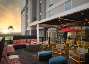 a patio with chairs and tables and a fire pit at Home2 Suites By Hilton Jackson/Pearl, Ms in Pearl