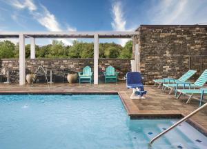 eine Terrasse mit Stühlen und einem Pool in der Unterkunft Home2 Suites By Hilton Jackson/Pearl, Ms in Pearl