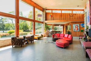 ein Wohnzimmer mit roten Möbeln und großen Fenstern in der Unterkunft Wiseacre Estate in Norfolk
