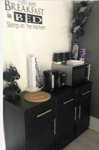 a black counter with a microwave on top of it at Belfast private room, en-suite & own access in Belfast