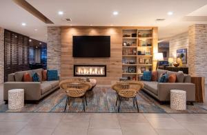 a living room with two couches and a fireplace at SunCoast Hotel Anaheim, Tapestry Collection by Hilton in Anaheim