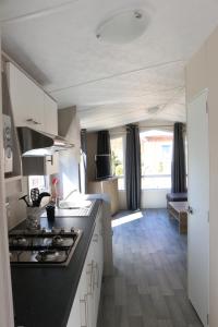 a kitchen with a black counter top in a caravan at Mobilheim Seeschwalbe am Kransburger See 542 in Kransburg