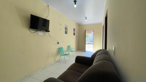 a living room with a couch and a tv on a wall at Recanto 3 irmãs in Barreirinhas