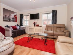 a living room with a couch and a red rug at 1 Cockerill Fold in Beverley