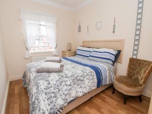 um quarto com uma cama, uma cadeira e uma janela em 1 Cockerill Fold em Beverley