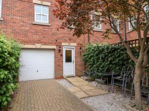 a brick building with two garage doors and chairs at 1 Cockerill Fold in Beverley
