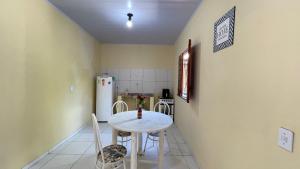 a kitchen with a table and chairs and a refrigerator at Recanto 3 irmãs in Barreirinhas