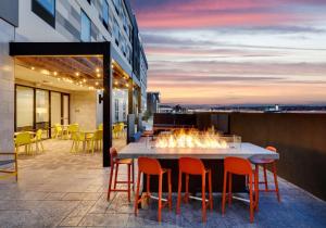 a table and chairs on a balcony with a fire pit at Home2 Suites By Hilton Euless Dfw West, Tx in Euless