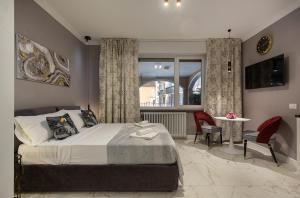a bedroom with a bed and a table and a window at Emerald Suites in Stresa