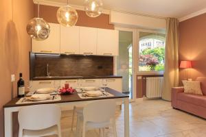 a kitchen with a table and chairs in a room at Emerald Suites in Stresa