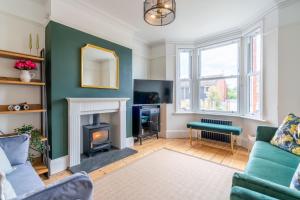 a living room with a couch and a fireplace at Otley House in Cheltenham