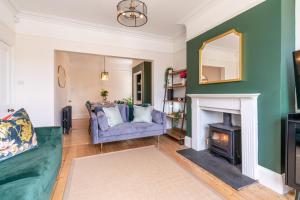 a living room with a blue couch and a fireplace at Otley House in Cheltenham