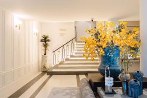 a lobby with a vase of yellow flowers and stairs at Bandalo Boutique Hotel in Patong Beach