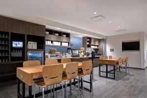 a restaurant with a bar with chairs and tables at Home2 Suites By Hilton Lewisville Dallas in Lewisville