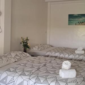 una camera da letto con due letti con asciugamani sopra di Mirka's Guest House a Isola di Bantayan Altre 15 foto