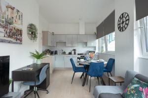 a kitchen and living room with a table and chairs at Deluxe 2 bed, 2 bathroom Milton Keynes apartment within walking distance to train station and City centre. in Milton Keynes