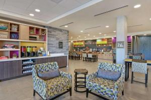 a waiting room with two chairs and a counter at Home2 Suites By Hilton Buckeye Phoenix in Buckeye
