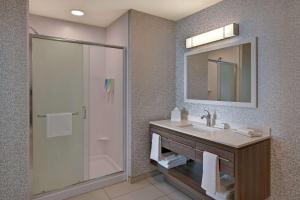 巴克艾Home2 Suites By Hilton Buckeye Phoenix的带水槽和淋浴的浴室（带镜子）