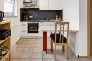 uma cozinha com uma mesa, cadeiras e um fogão em Ferienwohnung Im Bohrer em Donaueschingen