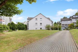 uma casa branca com um campo relvado à sua frente em Ferienwohnung Im Bohrer em Donaueschingen