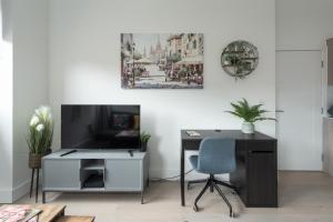 an office with a desk and a tv and a chair at Deluxe 2 bed, 2 bathroom Milton Keynes apartment within walking distance to train station and City centre. in Milton Keynes