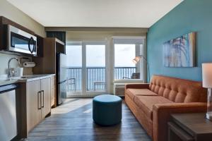 uma sala de estar com um sofá e uma varanda em Home2 Suites Ormond Beach Oceanfront, FL em Ormond Beach
