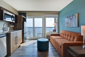 奥蒙德海滩Home2 Suites Ormond Beach Oceanfront, FL的带沙发和阳台的客厅